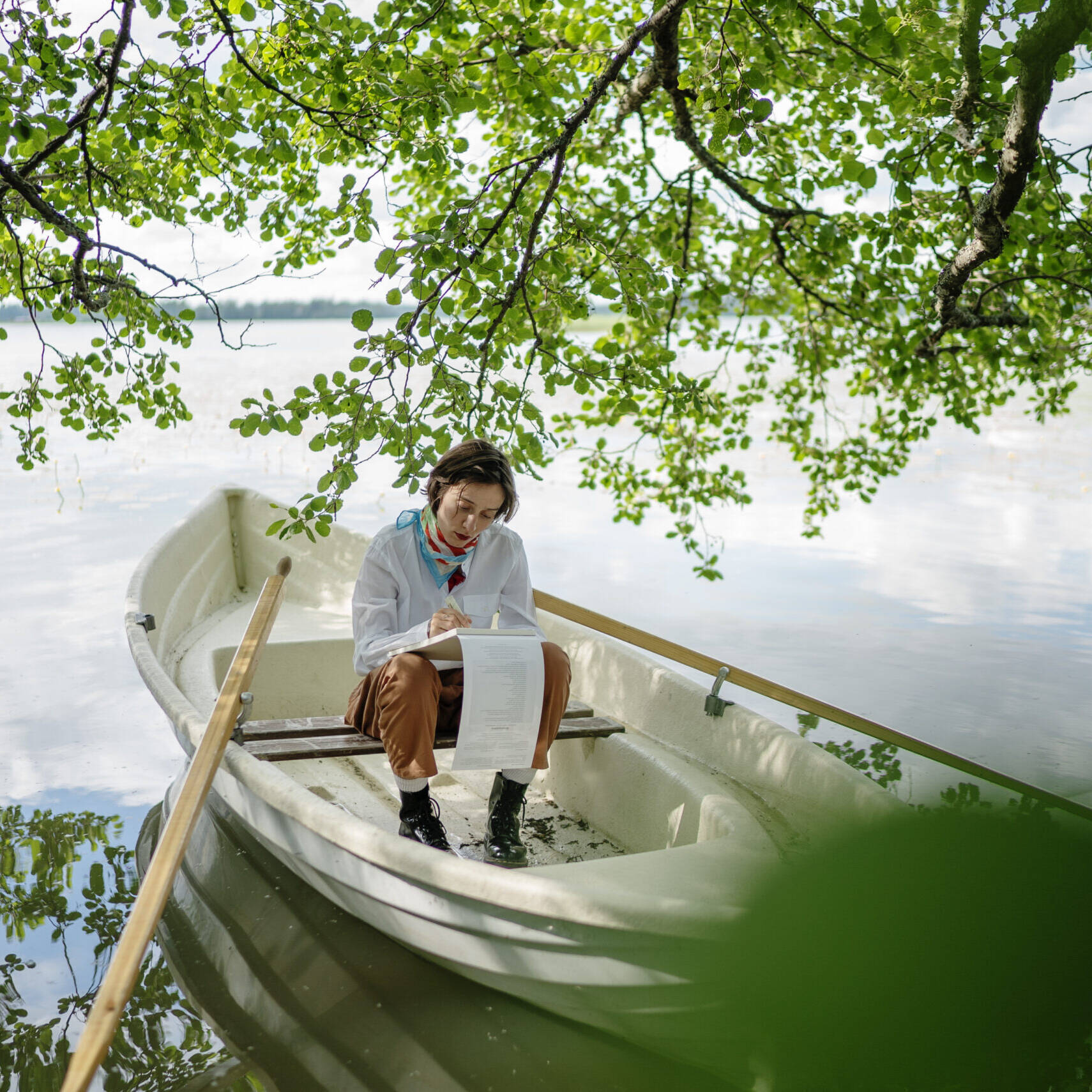 soutuvene ja nainen järvimaisemassa
