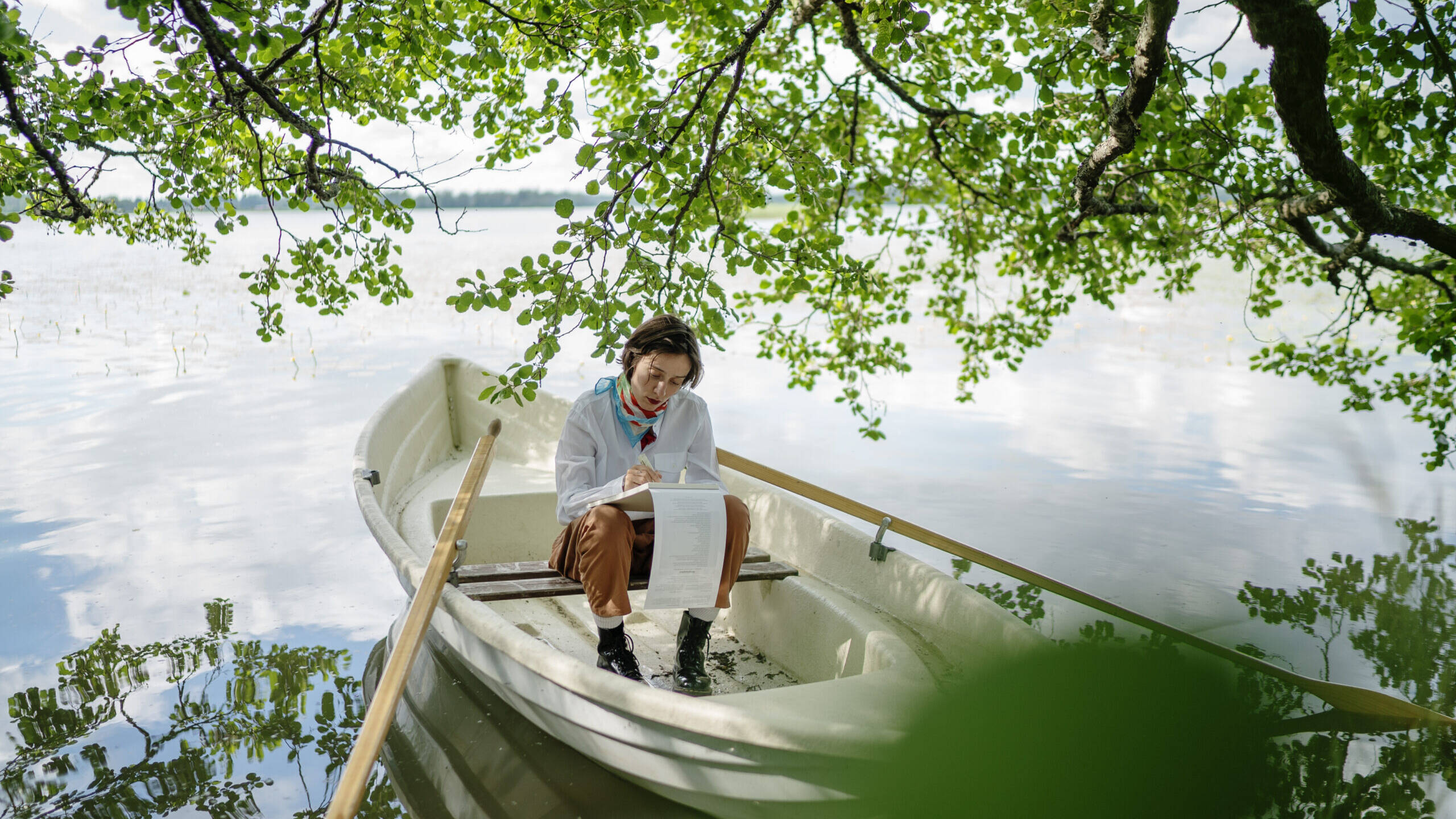 soutuvene ja nainen järvimaisemassa