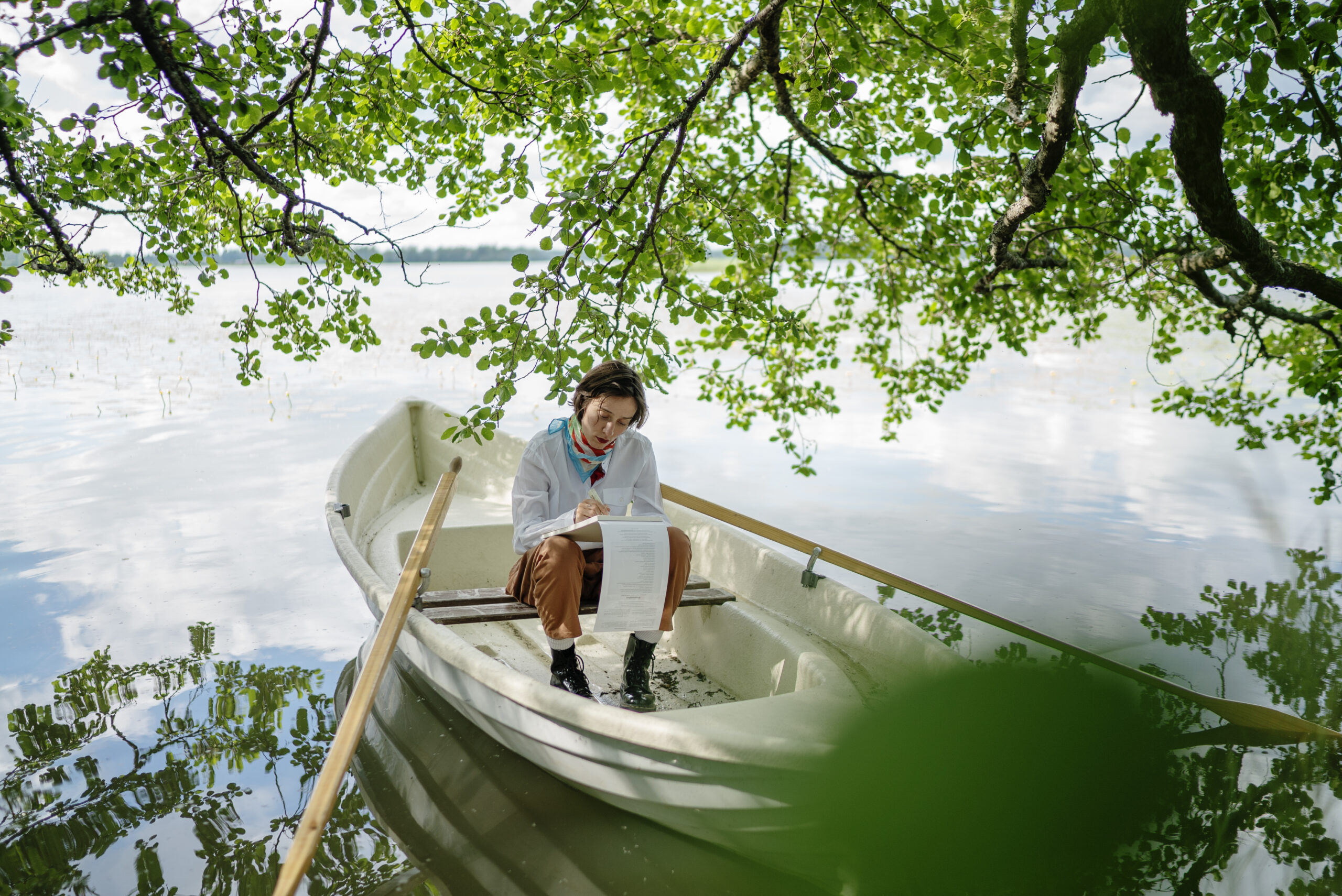 soutuvene ja nainen järvimaisemassa