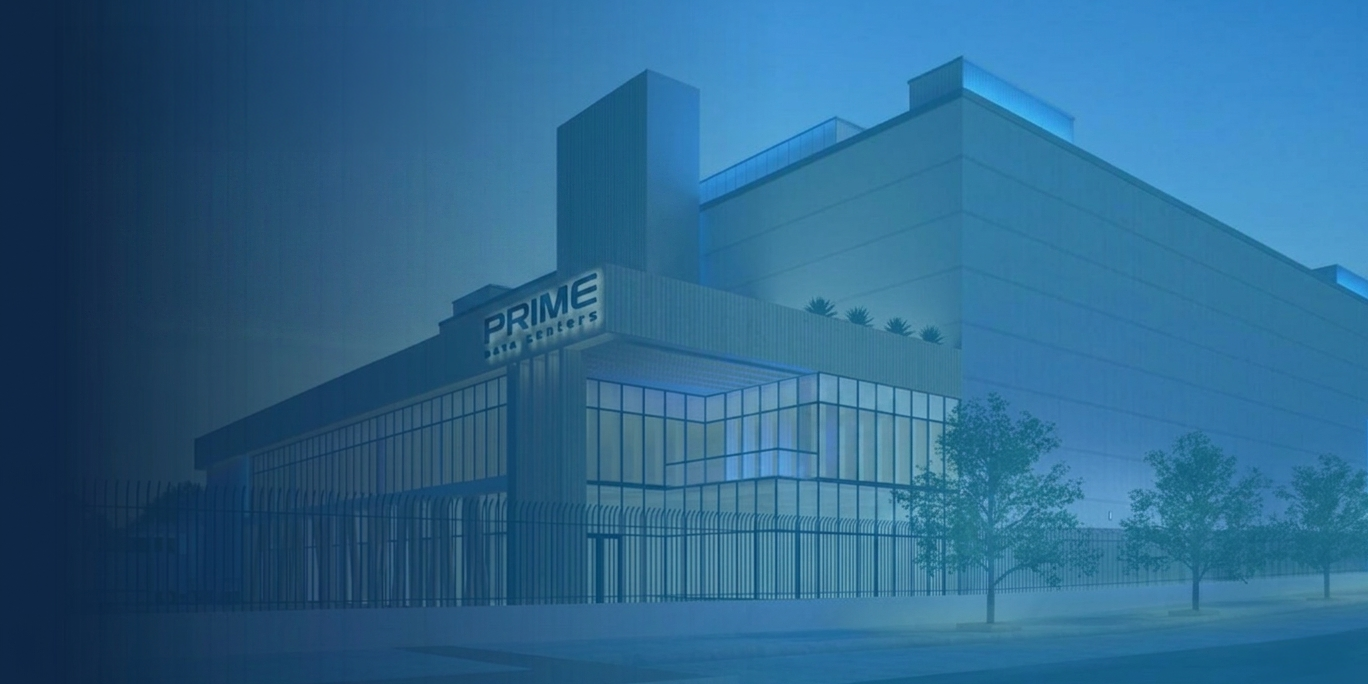 Moderni PRIME Data Centers -konesalirakennus sinisävyisessä valaistuksessa. Rakennuksen edustalla on korkea turva-aita ja ympärillä muutamia puita. Kuvassa korostuvat teknologinen ilme, suuret lasipinnat ja massiivinen infrastruktuuri.